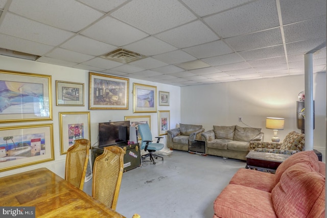 living room with concrete flooring and a paneled ceiling