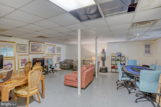 interior space featuring ceiling fan, a paneled ceiling, and concrete floors