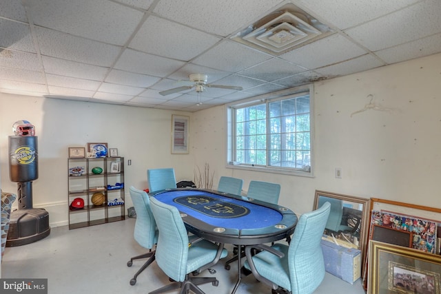 dining room with concrete floors, a drop ceiling, and ceiling fan