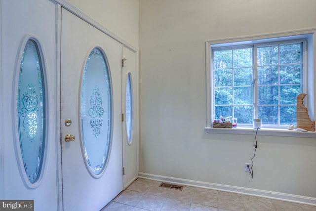 entryway with light tile patterned floors and a healthy amount of sunlight