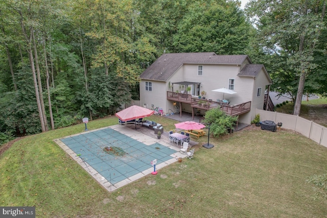 rear view of house with a lawn, a patio area, and a pool side deck