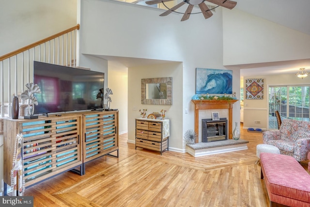 living room featuring ceiling fan, hardwood / wood-style flooring, and high vaulted ceiling