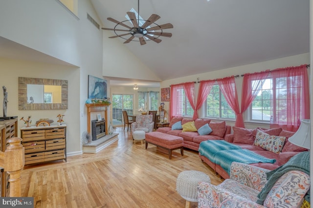 living room with ceiling fan, light hardwood / wood-style floors, and high vaulted ceiling