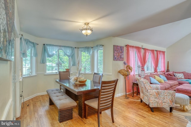 dining room with light hardwood / wood-style floors and lofted ceiling