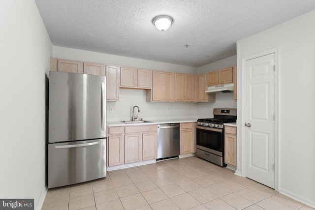 kitchen with appliances with stainless steel finishes, light tile patterned floors, a textured ceiling, light brown cabinetry, and sink