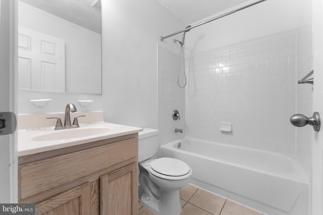 full bathroom featuring vanity, tiled shower / bath, a textured ceiling, and toilet