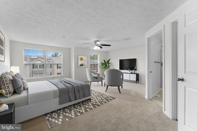 bedroom with ceiling fan, light colored carpet, and a textured ceiling