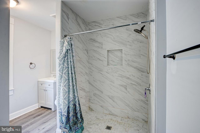 bathroom featuring hardwood / wood-style flooring, vanity, and walk in shower