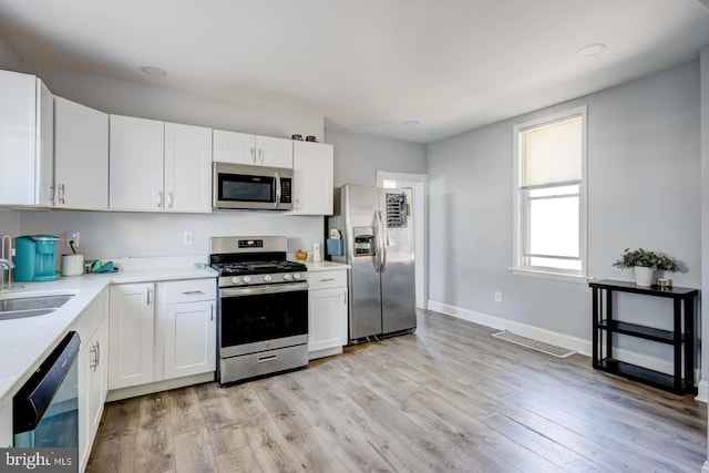 kitchen featuring light hardwood / wood-style floors, sink, stainless steel appliances, and white cabinets