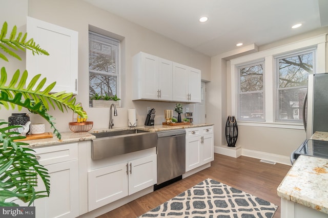 kitchen with dark hardwood / wood-style flooring, stainless steel appliances, and white cabinets