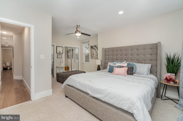 bedroom featuring ceiling fan, light wood-type flooring, a closet, and a spacious closet