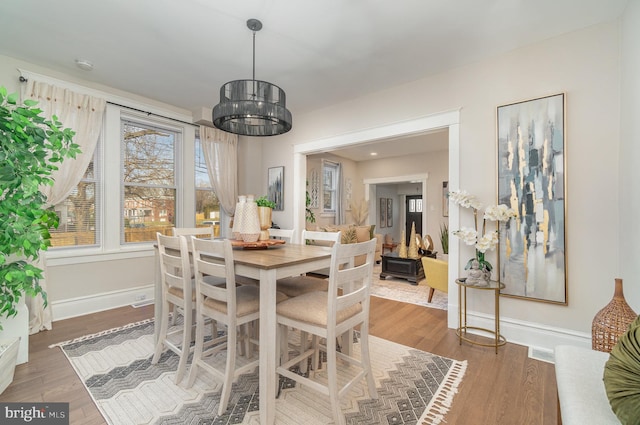 dining room featuring hardwood / wood-style flooring and a chandelier