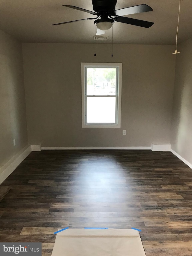 spare room with dark hardwood / wood-style flooring and ceiling fan