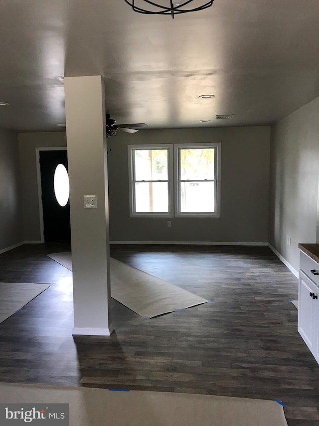 unfurnished room with ceiling fan and dark wood-type flooring