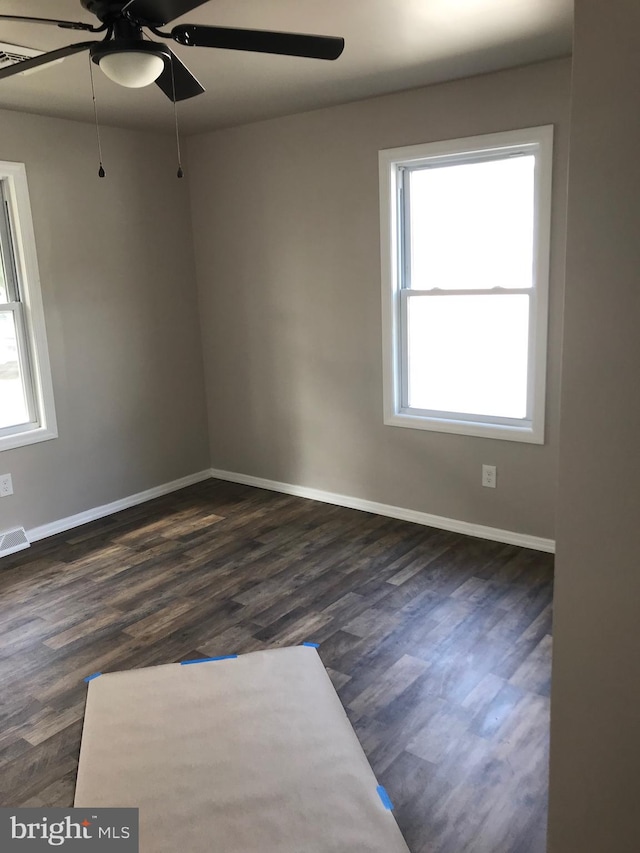 empty room featuring ceiling fan and dark hardwood / wood-style flooring