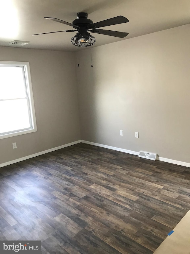 empty room featuring ceiling fan and dark wood-type flooring