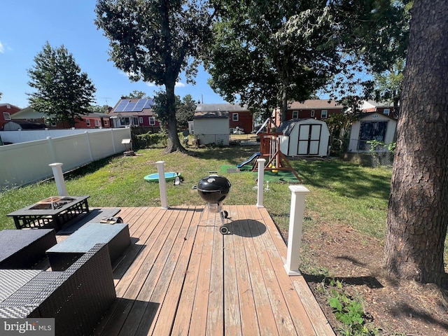 deck featuring a fire pit, a yard, and a shed