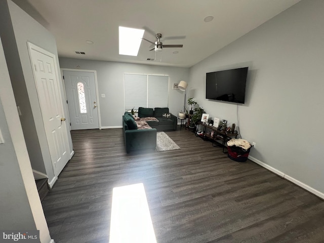 living room featuring vaulted ceiling with skylight, dark hardwood / wood-style floors, and ceiling fan