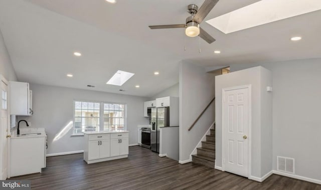 kitchen with stainless steel appliances, white cabinetry, ceiling fan, and dark hardwood / wood-style flooring