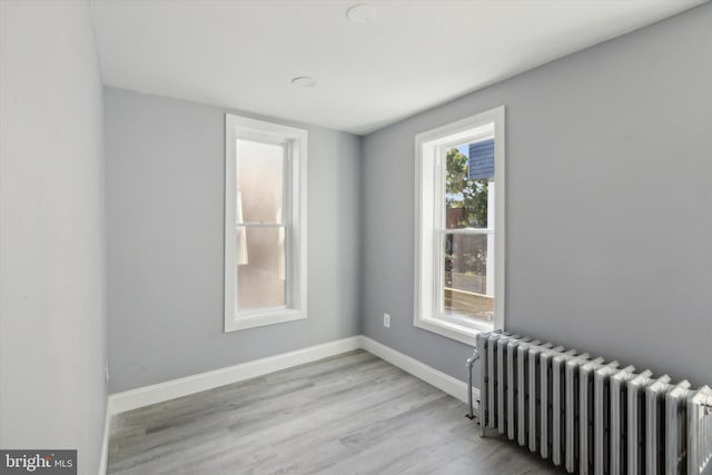 unfurnished room with light wood-type flooring and radiator