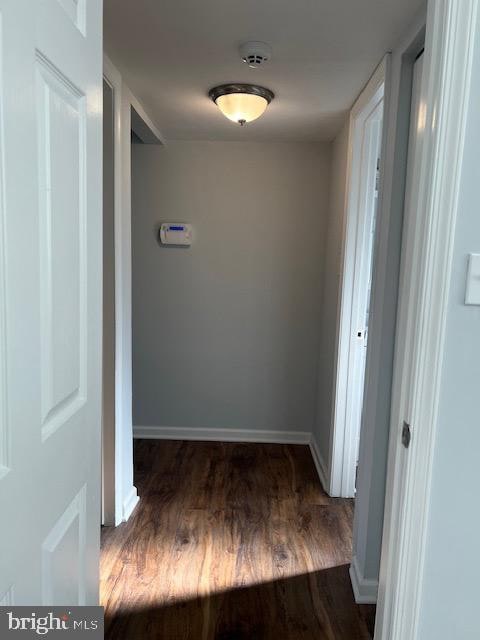 corridor with dark hardwood / wood-style floors