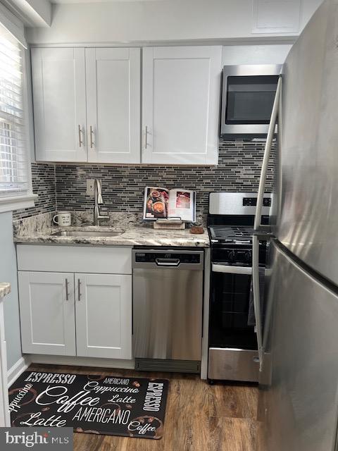 kitchen featuring white cabinetry, appliances with stainless steel finishes, sink, and dark wood-type flooring