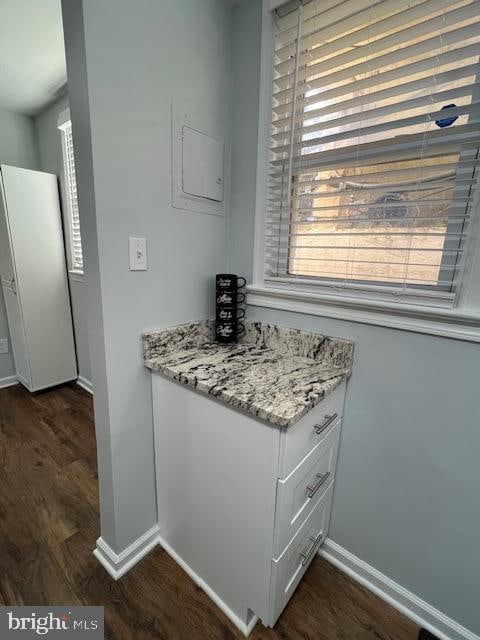 kitchen featuring white cabinetry, light stone counters, and dark hardwood / wood-style floors