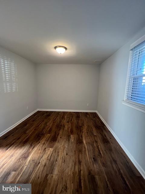 unfurnished room with dark hardwood / wood-style flooring