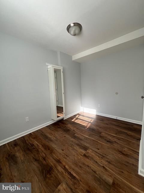 empty room with dark hardwood / wood-style floors