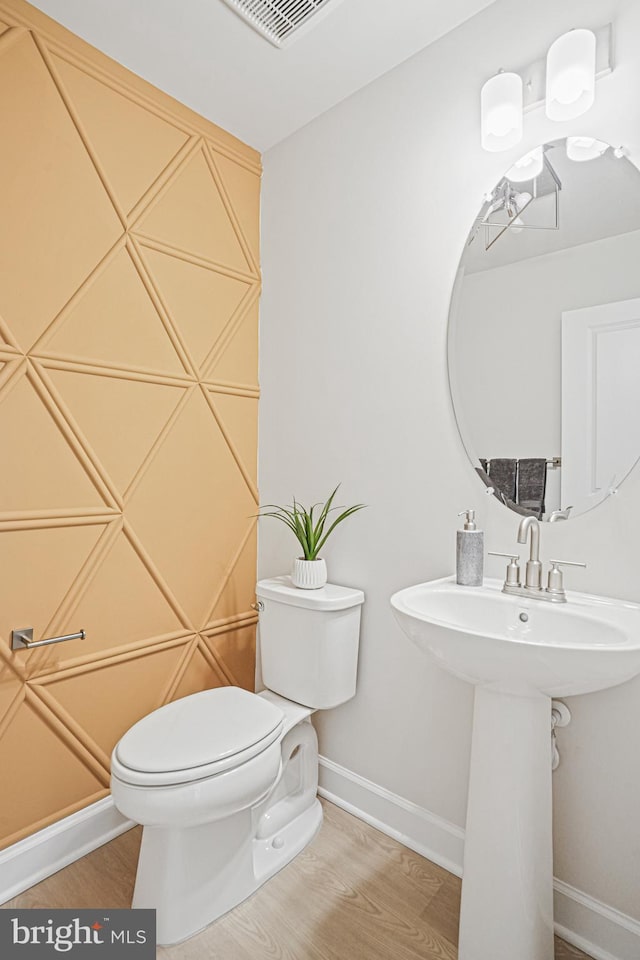 bathroom with hardwood / wood-style flooring, toilet, and sink