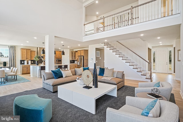 living room featuring a high ceiling and light hardwood / wood-style floors