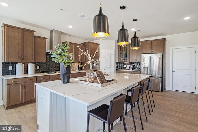 kitchen featuring tasteful backsplash, a large island, pendant lighting, and appliances with stainless steel finishes