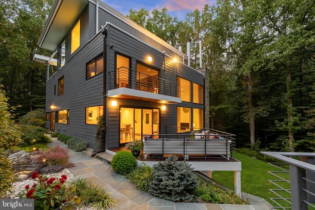 view of front facade featuring a lawn and a balcony