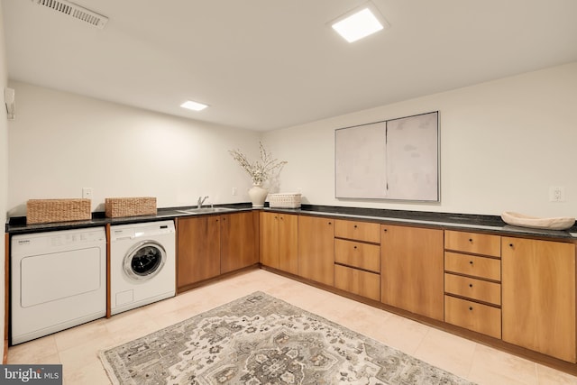 laundry room with cabinets, independent washer and dryer, sink, and light tile patterned floors