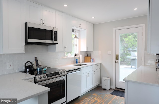 kitchen with stainless steel appliances, plenty of natural light, sink, and white cabinetry