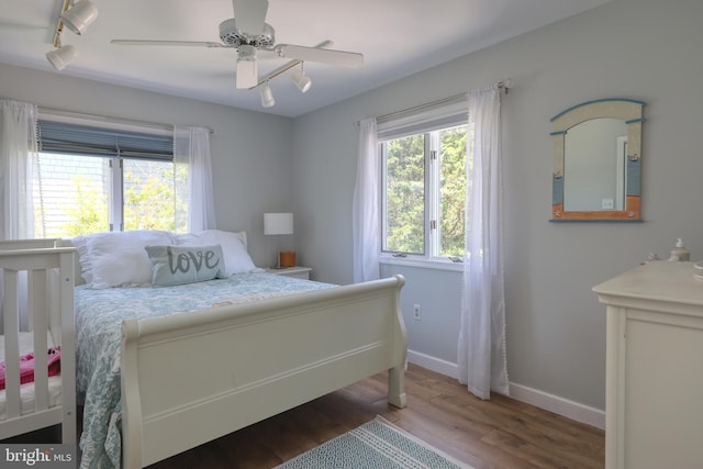 bedroom featuring ceiling fan, dark hardwood / wood-style flooring, and rail lighting