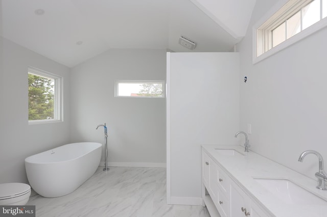 bathroom featuring a bathtub, vaulted ceiling, toilet, and vanity