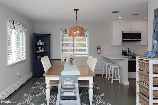 dining space featuring dark hardwood / wood-style flooring and a baseboard heating unit