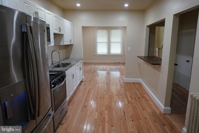 kitchen featuring light hardwood / wood-style flooring, stainless steel appliances, sink, and white cabinetry