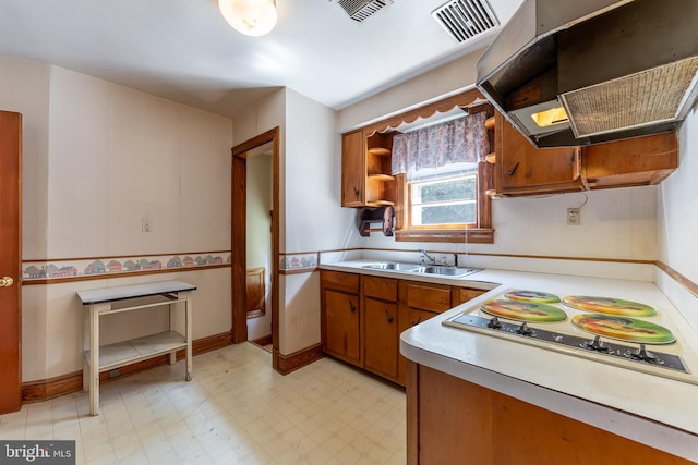 kitchen with white gas cooktop, range hood, and sink