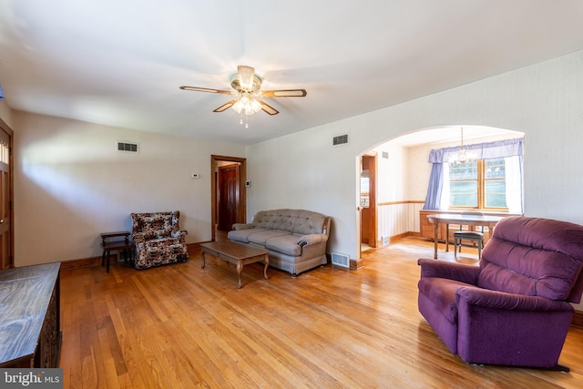 living room with light hardwood / wood-style flooring and ceiling fan with notable chandelier