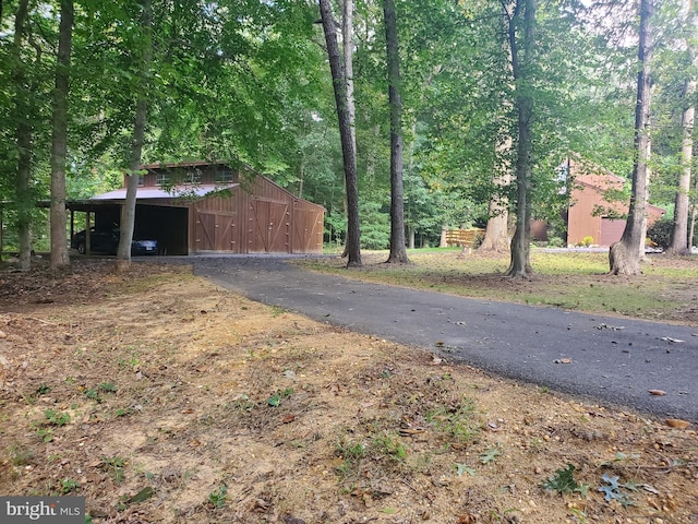view of street with a pole building and aphalt driveway