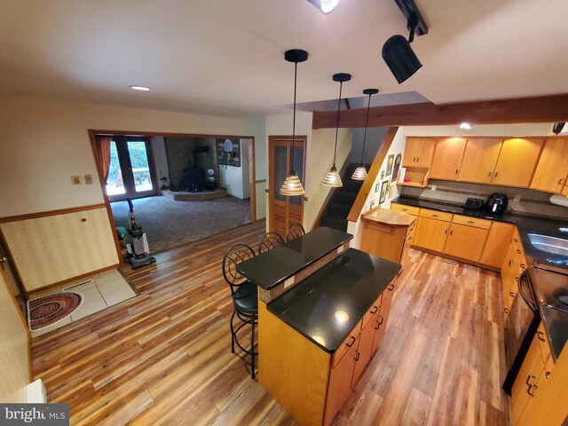 kitchen featuring a breakfast bar, light hardwood / wood-style floors, a center island, and pendant lighting