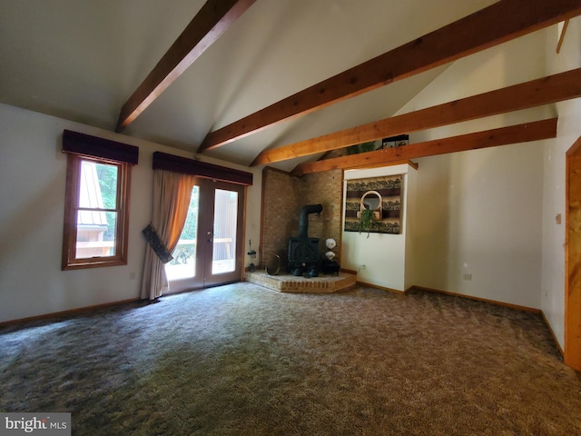 unfurnished living room with carpet, vaulted ceiling with beams, a wood stove, and french doors