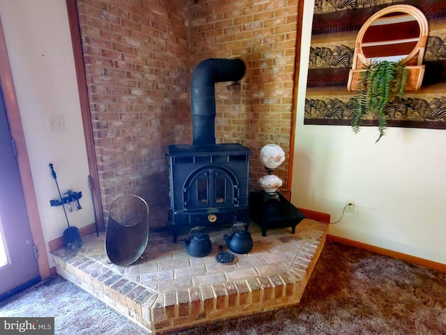 room details featuring carpet flooring, baseboards, and a wood stove
