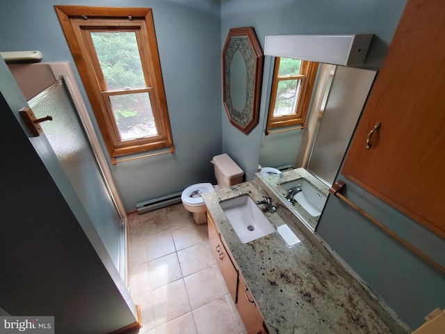 bathroom featuring vanity, toilet, a healthy amount of sunlight, and tile patterned flooring