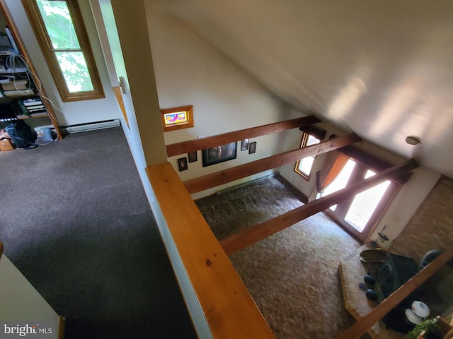 staircase featuring baseboard heating, lofted ceiling, and carpet