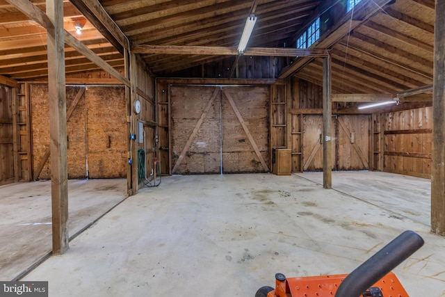 misc room with lofted ceiling and concrete floors