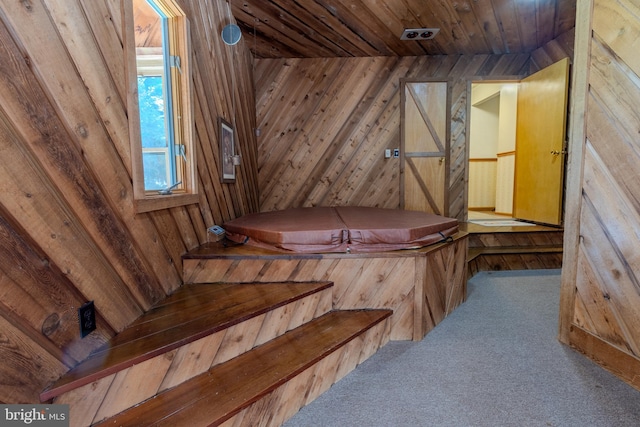 staircase with wood ceiling, carpet floors, wooden walls, and a jacuzzi