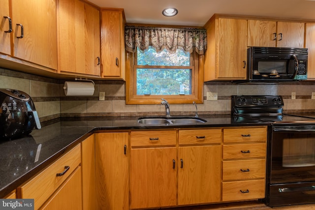 kitchen with sink, black appliances, decorative backsplash, and dark stone countertops